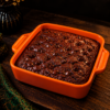 glossy chocolate brownie in orange dish